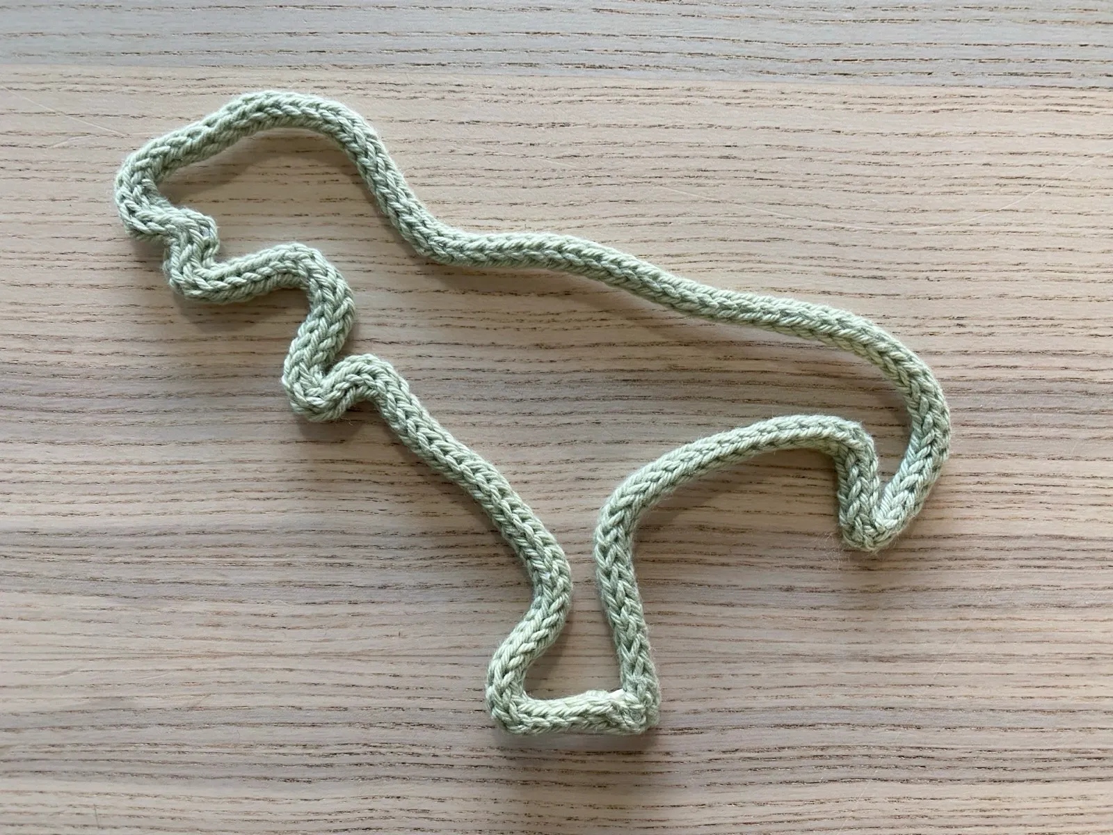Dinosaur: A friendly knitted dinosaur outline.
